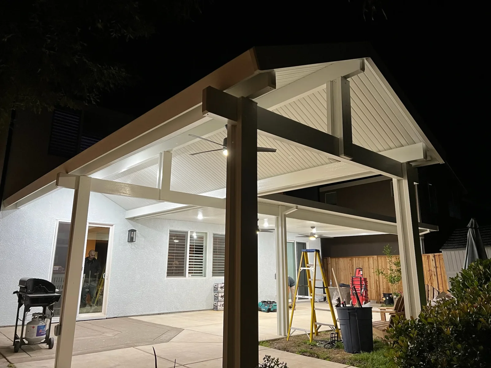 Cream aluminum gazebo with gable roof, polycarbonate panels, and integrated LED lighting over patio